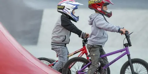 Dwóch chłopców w kaskach na rowerach BMX gotowych do zjazdu. Idealne rzeszów atrakcje dla dzieci do aktywnego spędzania czasu.