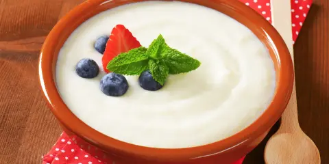 Aksamitna kasza manna dla niemowlaka, udekorowana truskawką, borówkami i miętą. Idealny posiłek dla malucha.