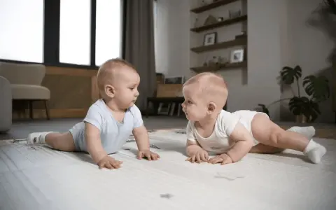 Dwa niemowlaki na macie, odkrywające świat w pierwszych 1000 dniach życia.